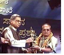 Director Rajshekhar receiving Puttanna Kanagal Award from CM S.M. Krishna